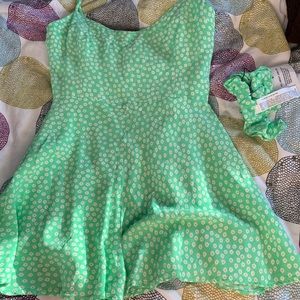 a green floral romper with a matching scrunchie
